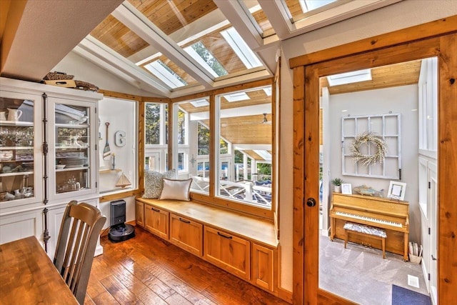 sunroom / solarium featuring lofted ceiling with skylight and wood ceiling