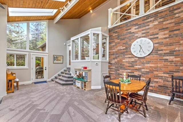 dining area featuring a high ceiling, wooden ceiling, carpet flooring, baseboards, and stairs