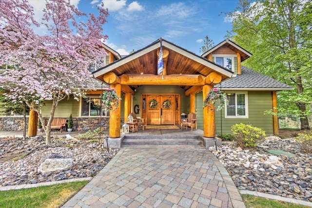 view of front of home featuring a porch, french doors, and a shingled roof