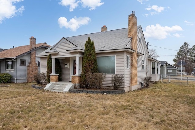 view of front of property with a chimney, a front yard, and fence