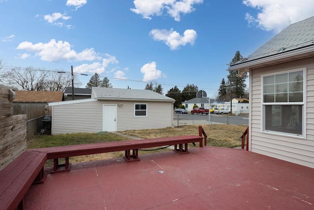 deck with a patio area, an outdoor structure, and fence