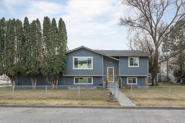 bi-level home featuring a fenced front yard, a front yard, and entry steps