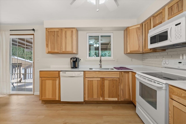 kitchen with light wood finished floors, ceiling fan, light countertops, white appliances, and a sink