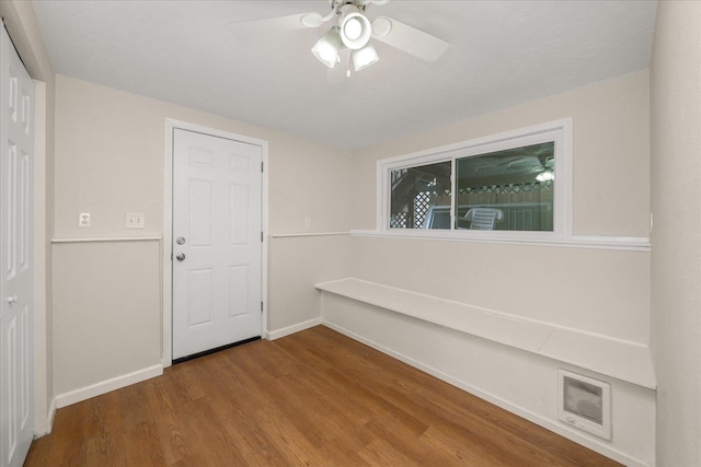 unfurnished room featuring a ceiling fan, wood finished floors, visible vents, and baseboards