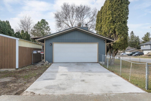 garage featuring fence and driveway