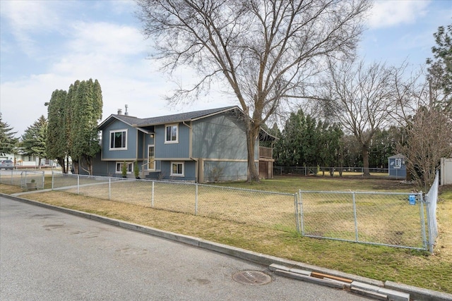 split foyer home with a shed, fence private yard, a front yard, an outdoor structure, and driveway