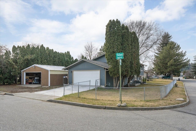 view of front of home featuring an outdoor structure, concrete driveway, and fence