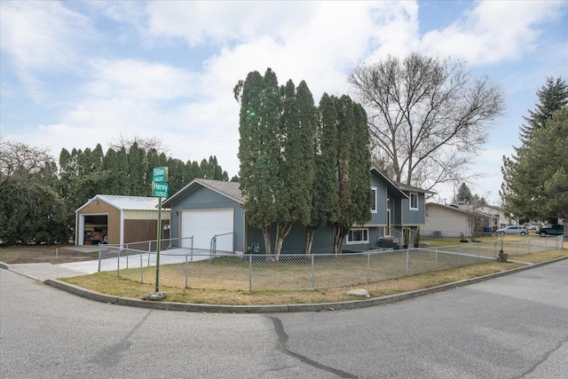 view of front of home featuring an outbuilding, a garage, and a fenced front yard