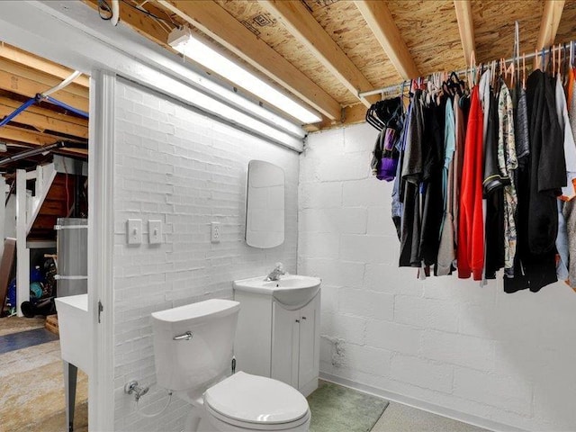 bathroom with a walk in closet, toilet, and vanity