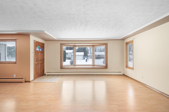 interior space with light wood finished floors, plenty of natural light, and baseboard heating