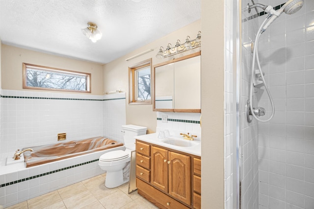 bathroom with toilet, a textured ceiling, a tile shower, a bath, and vanity