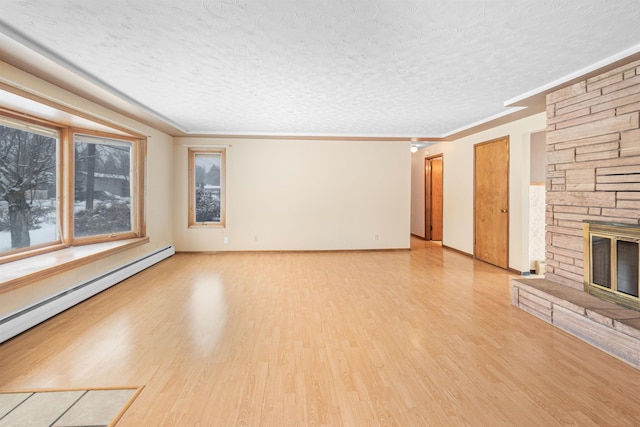 unfurnished living room featuring a baseboard radiator, a textured ceiling, a stone fireplace, and wood finished floors