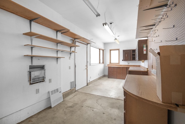 interior space featuring open shelves, unfinished concrete floors, and light countertops