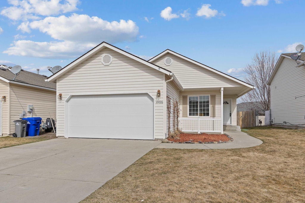 ranch-style house featuring concrete driveway, a porch, a garage, and a front yard