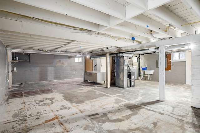 below grade area featuring heating unit, plenty of natural light, and a sink