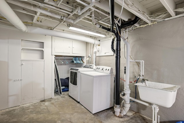 laundry room with cabinet space, independent washer and dryer, and a sink