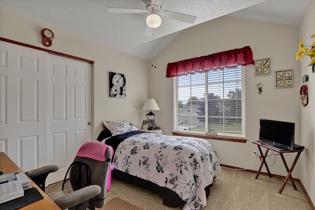 carpeted bedroom with lofted ceiling, a ceiling fan, baseboards, and a textured ceiling