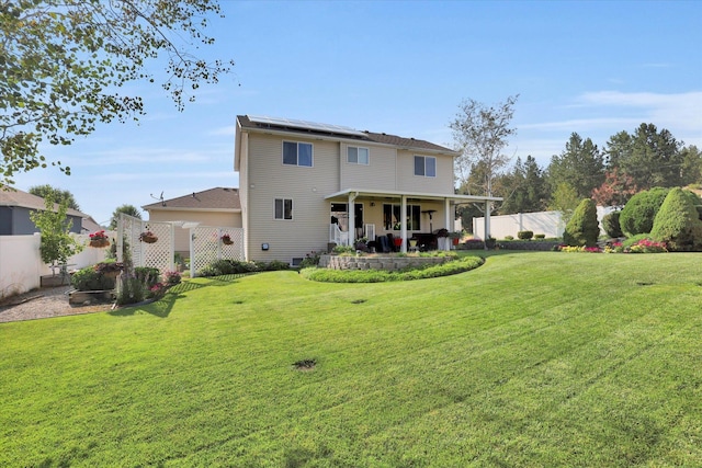 back of house featuring a patio, a yard, a fenced backyard, and roof mounted solar panels