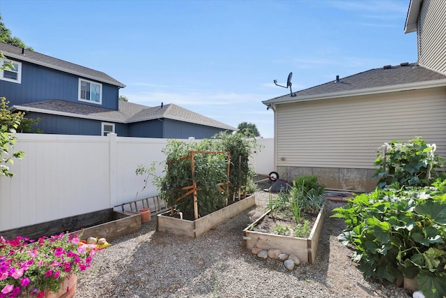 view of yard with a vegetable garden and fence