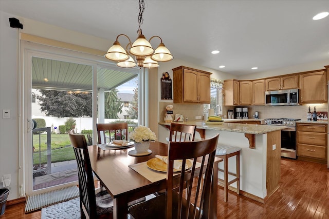 dining room with recessed lighting, an inviting chandelier, and wood finished floors