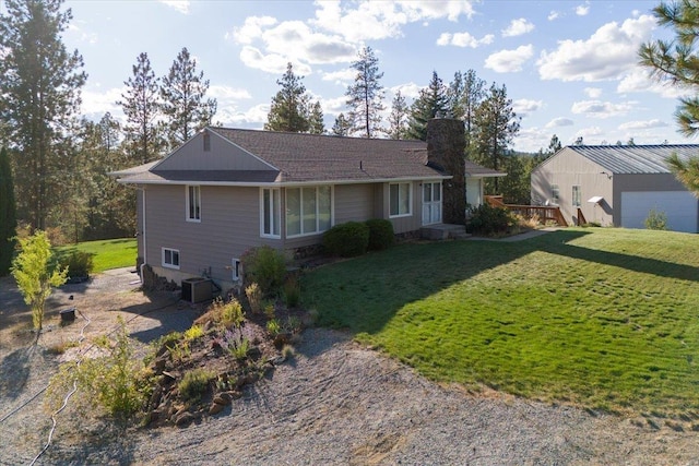 back of property featuring central AC unit, a lawn, and a chimney