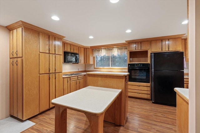 kitchen with recessed lighting, light wood-style floors, black appliances, and light countertops