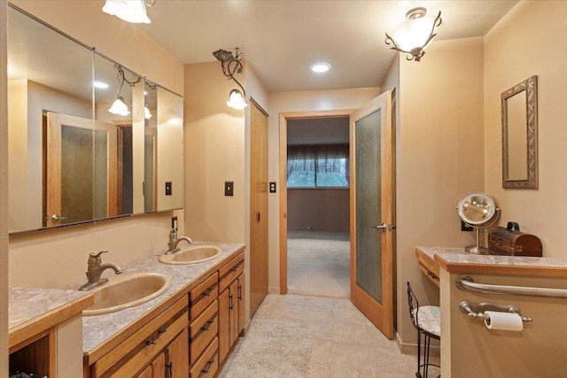 bathroom with a sink, baseboards, and double vanity