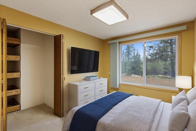 bedroom with light colored carpet and a textured ceiling