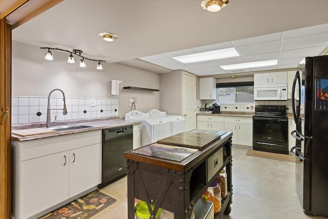 kitchen featuring a sink, decorative backsplash, separate washer and dryer, and black appliances