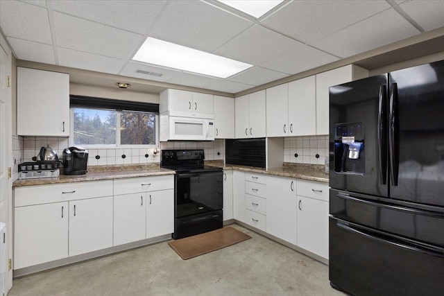 kitchen featuring concrete floors, visible vents, black appliances, and white cabinets