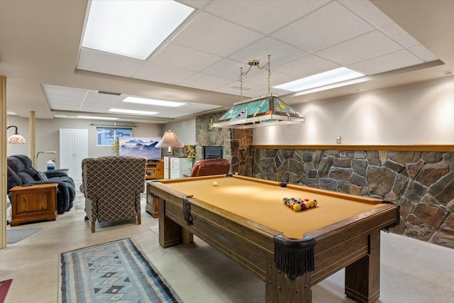 rec room with a drop ceiling, pool table, finished concrete floors, and a fireplace