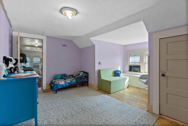 bedroom featuring wood finished floors and vaulted ceiling