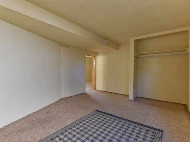 unfurnished bedroom with light carpet and a closet