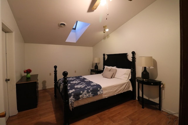 bedroom with lofted ceiling with skylight, visible vents, a ceiling fan, and wood finished floors