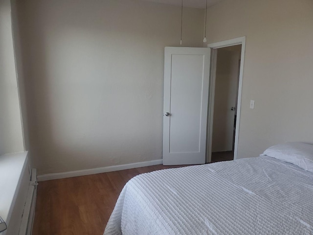 bedroom with baseboards and wood finished floors