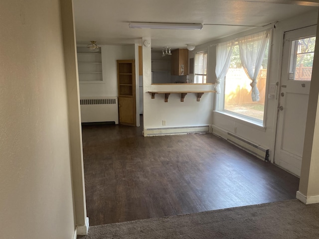 kitchen with a baseboard radiator, radiator heating unit, dark wood-style flooring, a kitchen bar, and baseboard heating