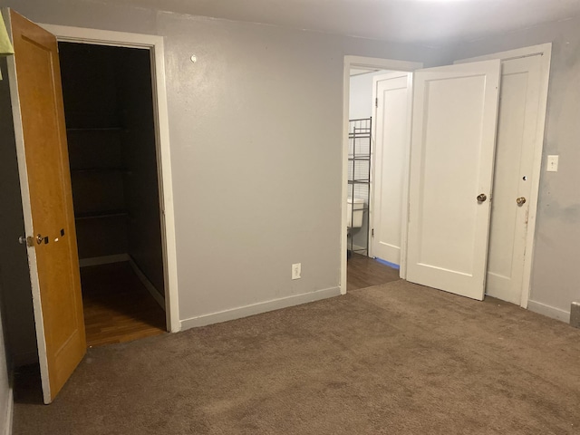 unfurnished bedroom featuring a closet, baseboards, and carpet