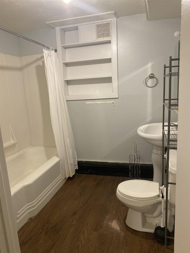 full bathroom featuring toilet, shower / bath combo, and wood finished floors