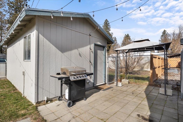 view of outdoor structure with a gazebo, fence, and an outbuilding