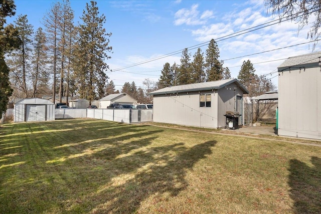 view of yard with fence, an outdoor structure, and a shed