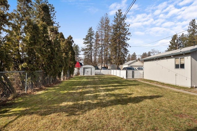 view of yard with an outbuilding, a fenced backyard, and a shed