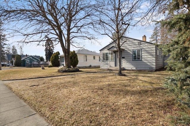 view of front of home with a front lawn and a chimney