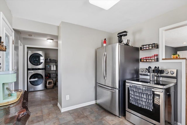 kitchen featuring stacked washer and dryer, baseboards, and stainless steel appliances