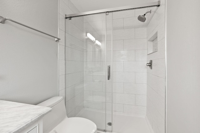 bathroom featuring vanity, toilet, and a stall shower