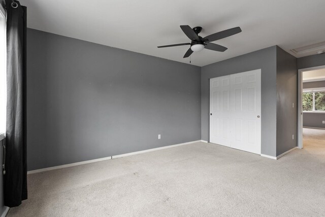 unfurnished bedroom with a closet, ceiling fan, baseboards, and carpet floors