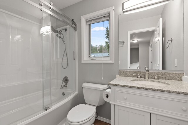 bathroom featuring vanity, toilet, and combined bath / shower with glass door