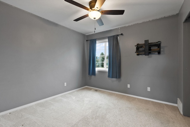 unfurnished room with carpet flooring, visible vents, a ceiling fan, and baseboards