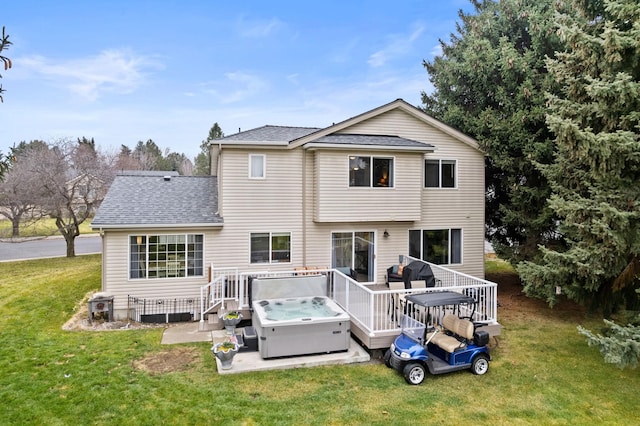 back of house with a deck, a patio, a yard, roof with shingles, and a hot tub