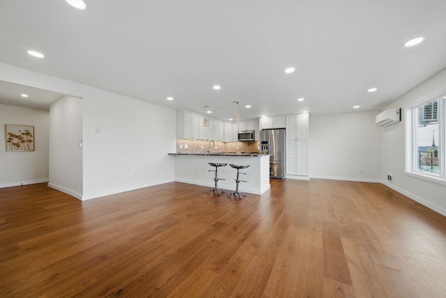 unfurnished living room featuring recessed lighting, light wood-type flooring, and baseboards