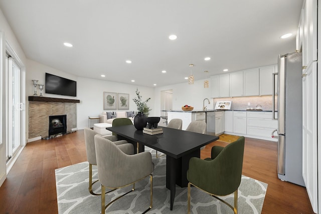 dining room with recessed lighting, wood finished floors, and a fireplace